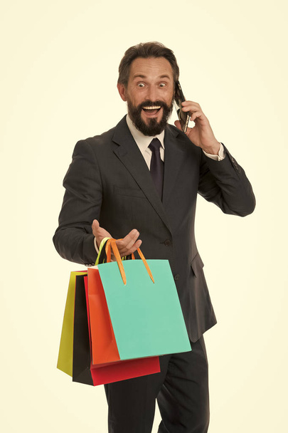 Smartphone kullanarak internet alışveriş yapmak adam. Kağıt poşet olan adam. Satın almak ve satmak online. Online iş yapmak çok kolaydır. İş için net sörf ve alışveriş keyfini çıkarın - Fotoğraf, Görsel