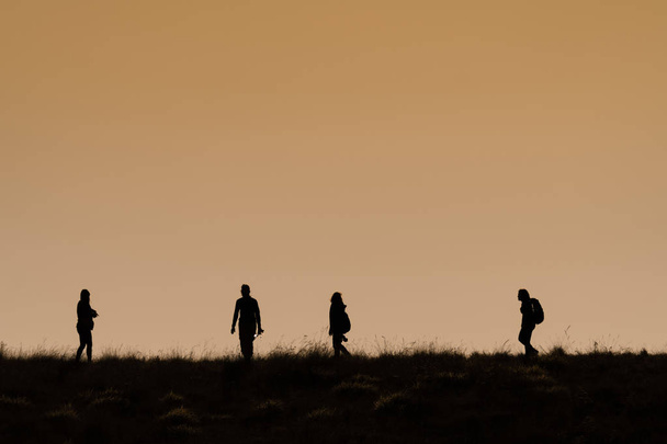 Silhouettes of hikers with backpacks enjoying sunset view from t - Φωτογραφία, εικόνα