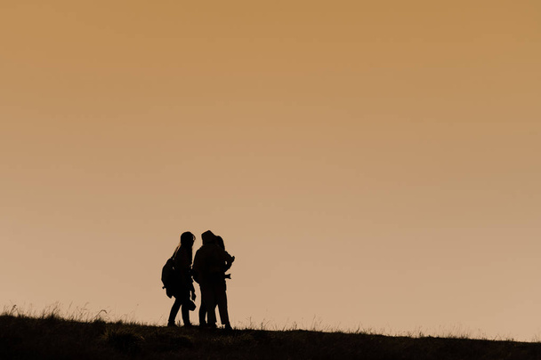 Silhouettes of hikers with backpacks enjoying sunset view from t - Photo, Image
