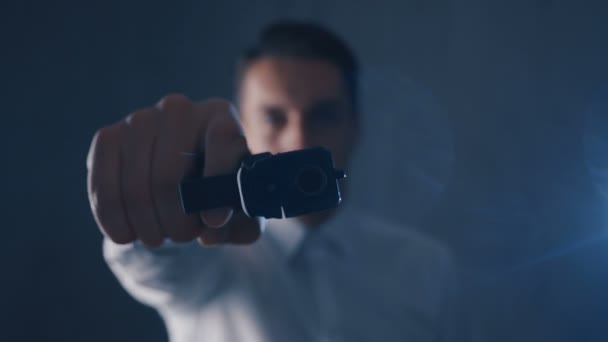 Uomo Criminale in camicia bianca che punta una pistola in una macchina fotografica. Concentrati sulla pistola
. - Filmati, video