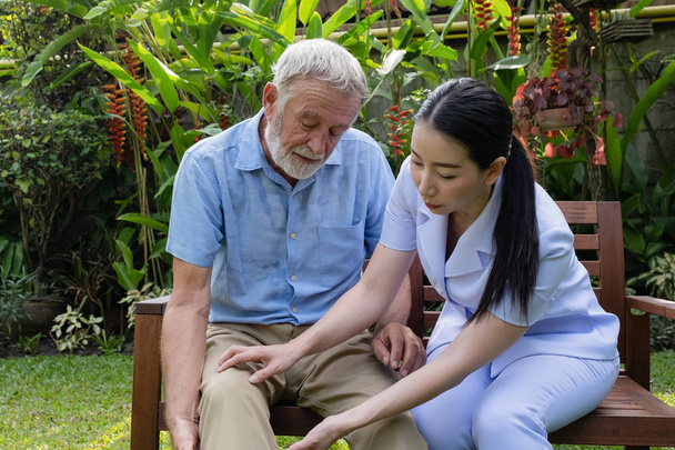 Senior-Mann Glück sitzt mit lächelnder Krankenschwester, kümmert sich um k - Foto, Bild