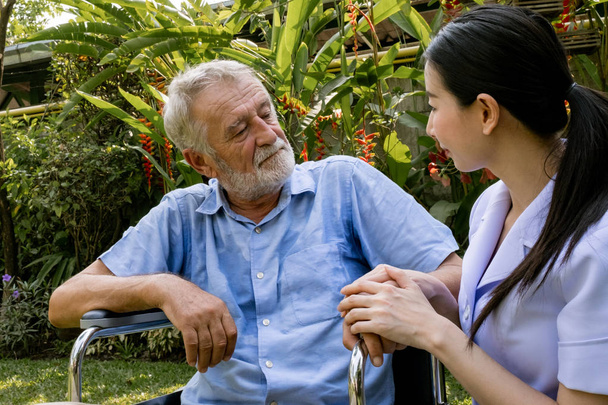 senior man happiness sitting on wheelchair with smiling nurse, t - Photo, Image