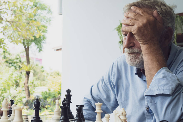 senior man playing chess at balcony near garden at nursing home  - Foto, immagini