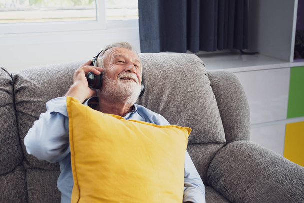 senior man happiness sitting on the sofa and listening music wit - Fotoğraf, Görsel