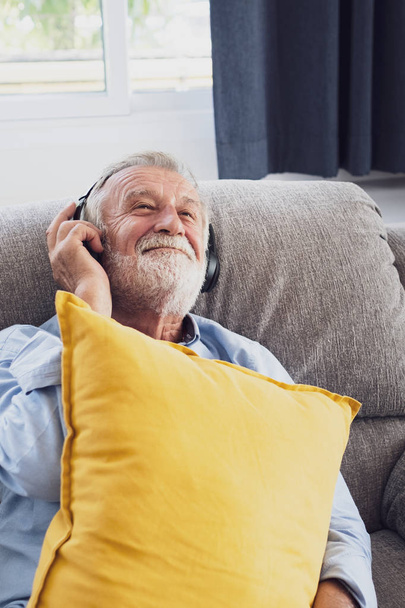 starszy człowiek szczęście siedzi na kanapie i słuchanie muzyki WIT - Zdjęcie, obraz