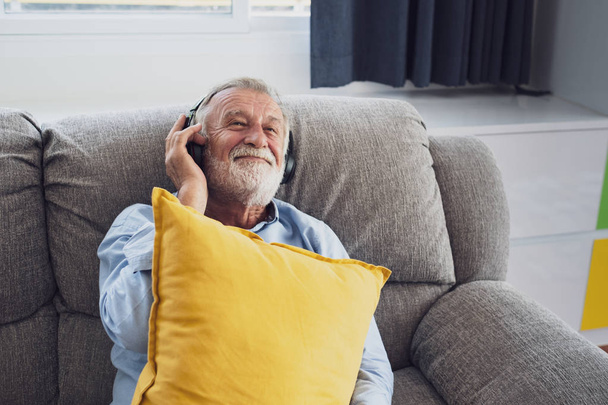 Senior man happiness sitting on the sofa and listening music wit
 - Фото, изображение