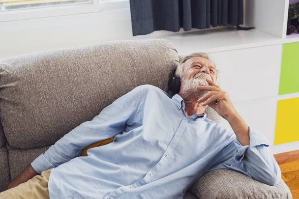 homem idoso felicidade sentado no sofá e ouvir música sagacidade
 - Foto, Imagem