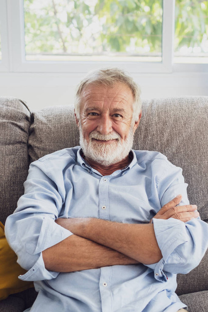 anziano uomo felicità seduta sul divano e sorridente e pollici
  - Foto, immagini
