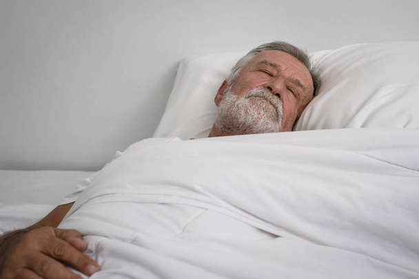 senior man sleeping alone on bed in room - Foto, Bild