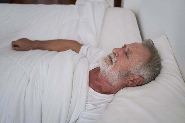senior man sleeping alone and headache or dreaming nightmare on  - Foto, imagen