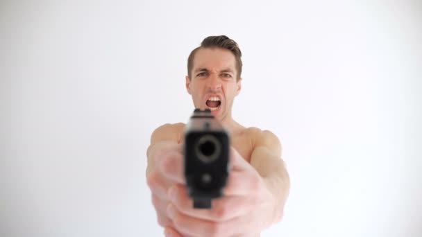 Çıplak adam beyaz arka plan üzerine silahını hedefliyor - Video, Çekim