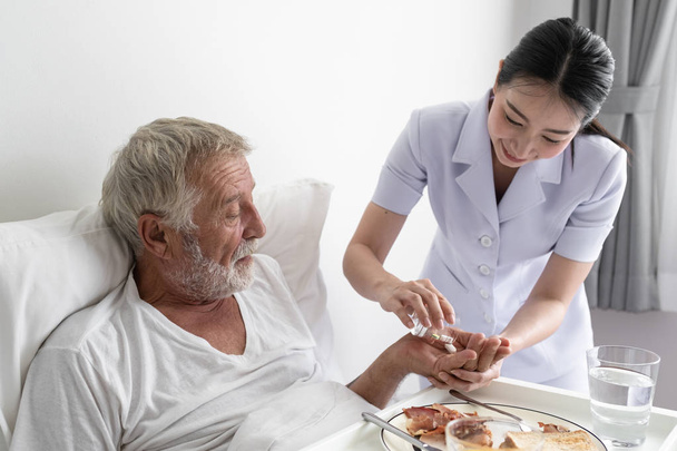 nurse give pill to senior man after breakfast and discussion on  - Photo, Image