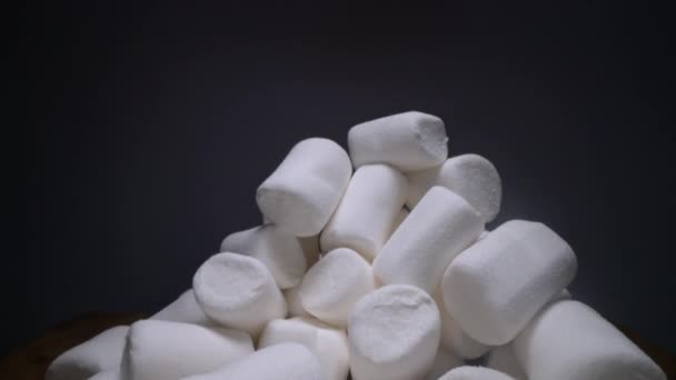 Hromada sladkého a měkkého Marshmallow. Bílé sladkosti na tmavém pozadí, rychlá strava - Záběry, video