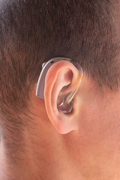 Крупный план уха со слуховым аппаратом
 - Фото, изображение