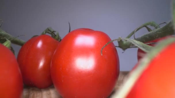 木製のテーブルの背景の上に赤い陽気なトマトのドリーショット。自家栽培野菜、健康的な食生活を滑る - 映像、動画
