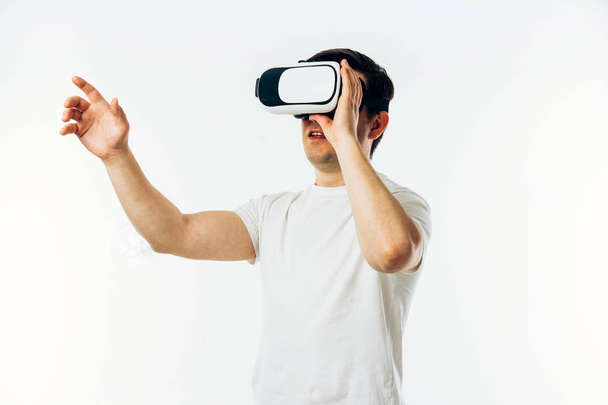 Человек в белой футболке в 3D-гарнитуре виртуальной реальности
  - Фото, изображение