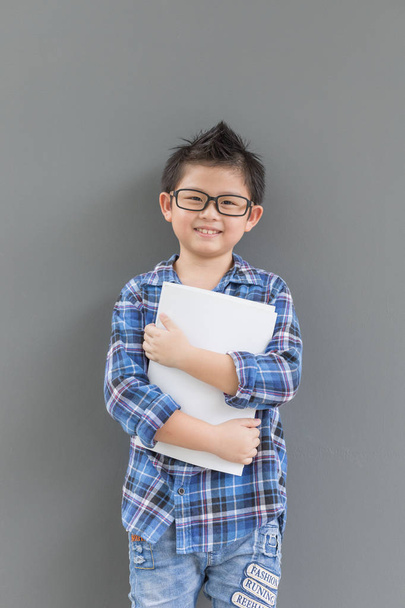 Aasialainen poika tuntee onnea, kun aika kouluun ja hänen kätensä pitävät
 - Valokuva, kuva