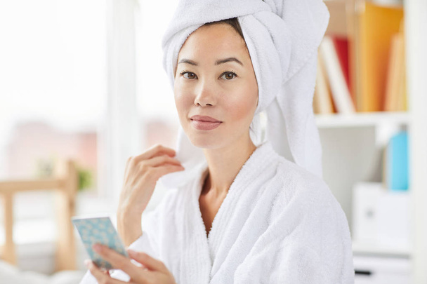 Retrato de mulher asiática lindo vestindo roupão de banho olhando para a câmera mostrando a pele fresca brilhante, espaço de cópia
 - Foto, Imagem
