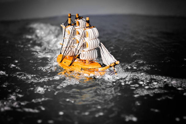 маленькая игрушечная лодка в воде с большими волнами, черно-белая
. - Фото, изображение