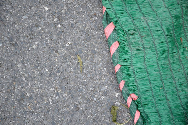 groen zonwering net op asfalt weg textuur - Foto, afbeelding