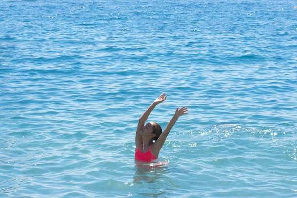 Nuori teini tyttö ui ja pitää hauskaa meressä
 - Valokuva, kuva