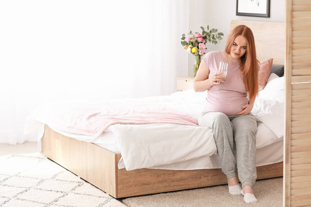 Nuori raskaana oleva nainen tuntuu pahalta kotona - Valokuva, kuva