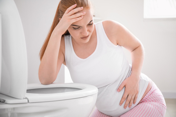 Junge Schwangere leidet an Toxikose in Toilette - Foto, Bild