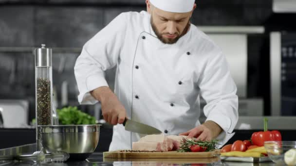 Kokki leikkaa porsaanfilettä keittiössä. Mies kokki valmistaa lihaa hidastettuna
 - Materiaali, video