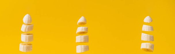 Foto panorámica de plátanos sabrosos y nutritivos en rodajas aislados en amarillo
 - Foto, Imagen