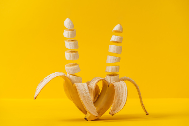Tropical fresh sliced delicious bananas isolated on yellow - Photo, Image
