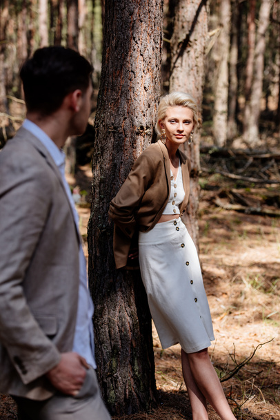 stylish bride and bridegroom standing in forest and looking at each other - Foto, afbeelding