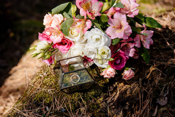 bouquet of fresh flowers and box with wedding rings - Fotó, kép