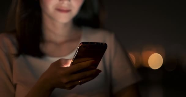 Mladá žena v noci ve městě volá taxi přes smartphone - Záběry, video