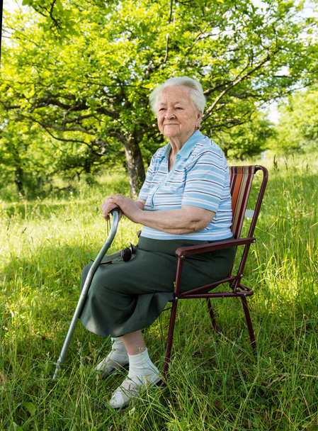 Vieille femme assise sur une chaise
 - Photo, image