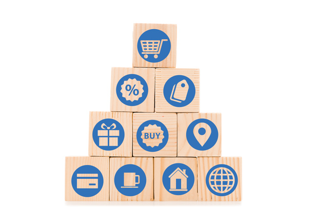 pirámide hecha de bloques de madera con iconos de compras azules aislados en blanco
 - Foto, Imagen