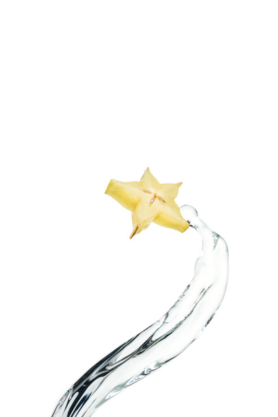 trozo de fruta estrella exótica y agua corriente aislada en blanco
 - Foto, Imagen