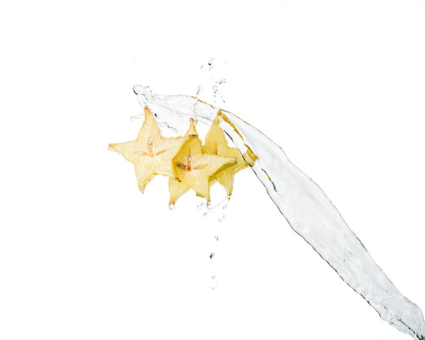 tasty exotic star fruit slices and water splash isolated on white - Photo, Image