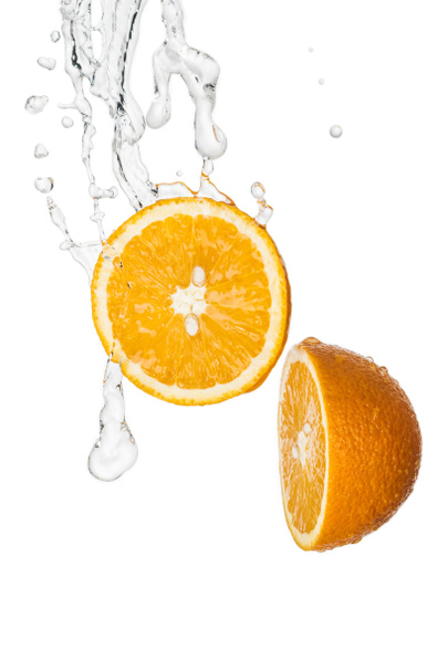 mitades de naranja fresca con salpicaduras de agua clara aisladas en blanco
 - Foto, Imagen