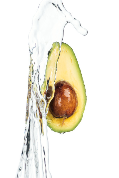 ripe nutritious avocado with seed and transparent water stream isolated on white  - Φωτογραφία, εικόνα