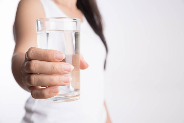 Un bicchiere di acqua minerale pulita nelle mani della donna. Concetto di protezione dell'ambiente, bevande sane e assistenza sanitaria
. - Foto, immagini