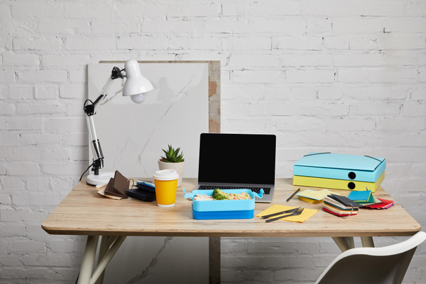 lunch box at workplace with laptop and papers on wooden table on white background, illustrative editorial - Photo, Image