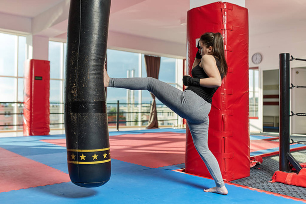 Muay thai female fighter training with the heavy bag - Fotografie, Obrázek