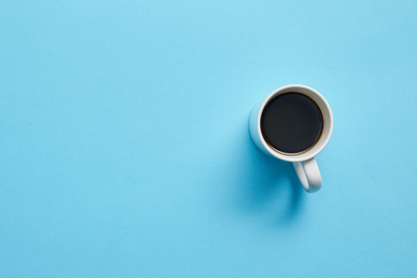 Top view of cup of hot coffee on blue background - Foto, Imagem