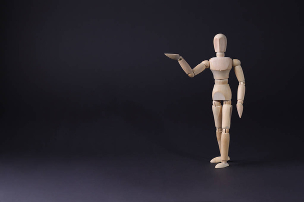 Een houten mannequin toont met zijn hand. Het concept van de wijzend  - Foto, afbeelding