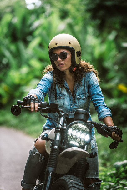 Female biker driving a cafe' racer motorbike - Photo, Image