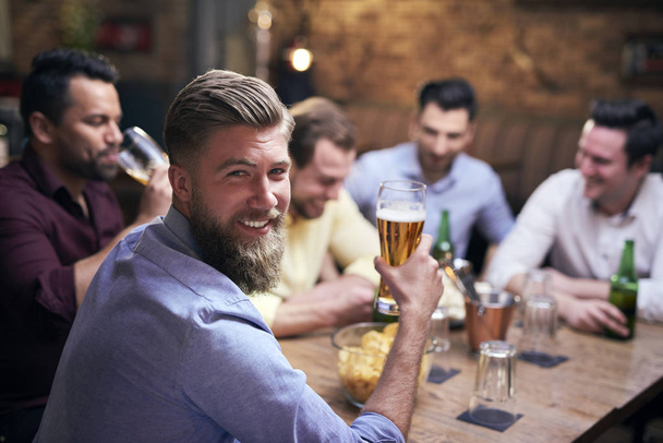 Ember iszik sört pub és barátai a háttérben   - Fotó, kép