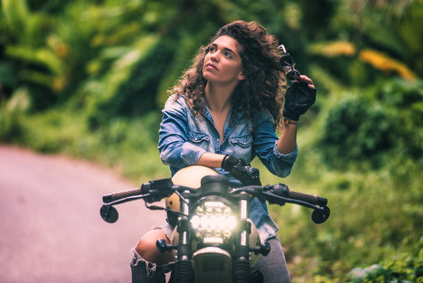 Female biker driving a cafe' racer motorbike - Фото, зображення