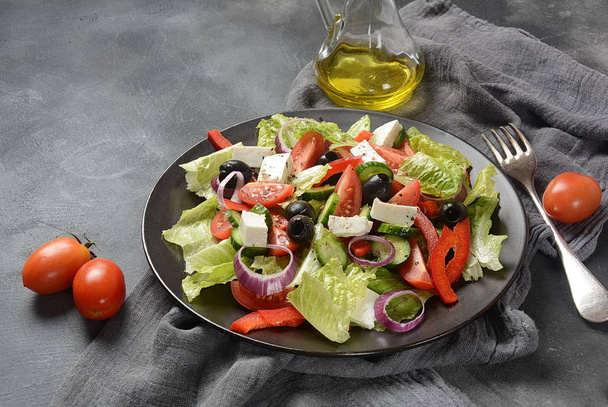 Greek salad with fresh cucumber, cherry tomatoes, sweet pepper, lettuce,red onion, olives and olive oil and feta cheese. Healthy food concept  - Foto, Bild
