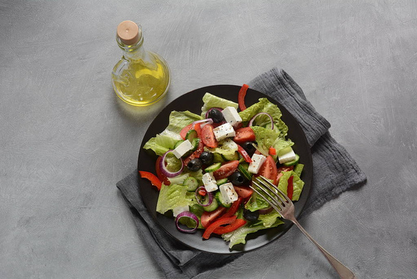 Greek salad with fresh cucumber, cherry tomatoes, sweet pepper, lettuce,red onion, olives and olive oil and feta cheese. Healthy food concept  - Foto, Imagem