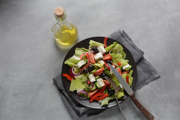 Greek salad with fresh cucumber, cherry tomatoes, sweet pepper, lettuce,red onion, olives and olive oil and feta cheese. Healthy food concept  - Valokuva, kuva